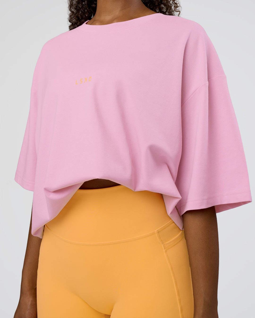 Woman wearing Together We Rise FLXCotton Oversized Tee - Bubblegum-Warm Apricot | Model:Jordan | Size:L