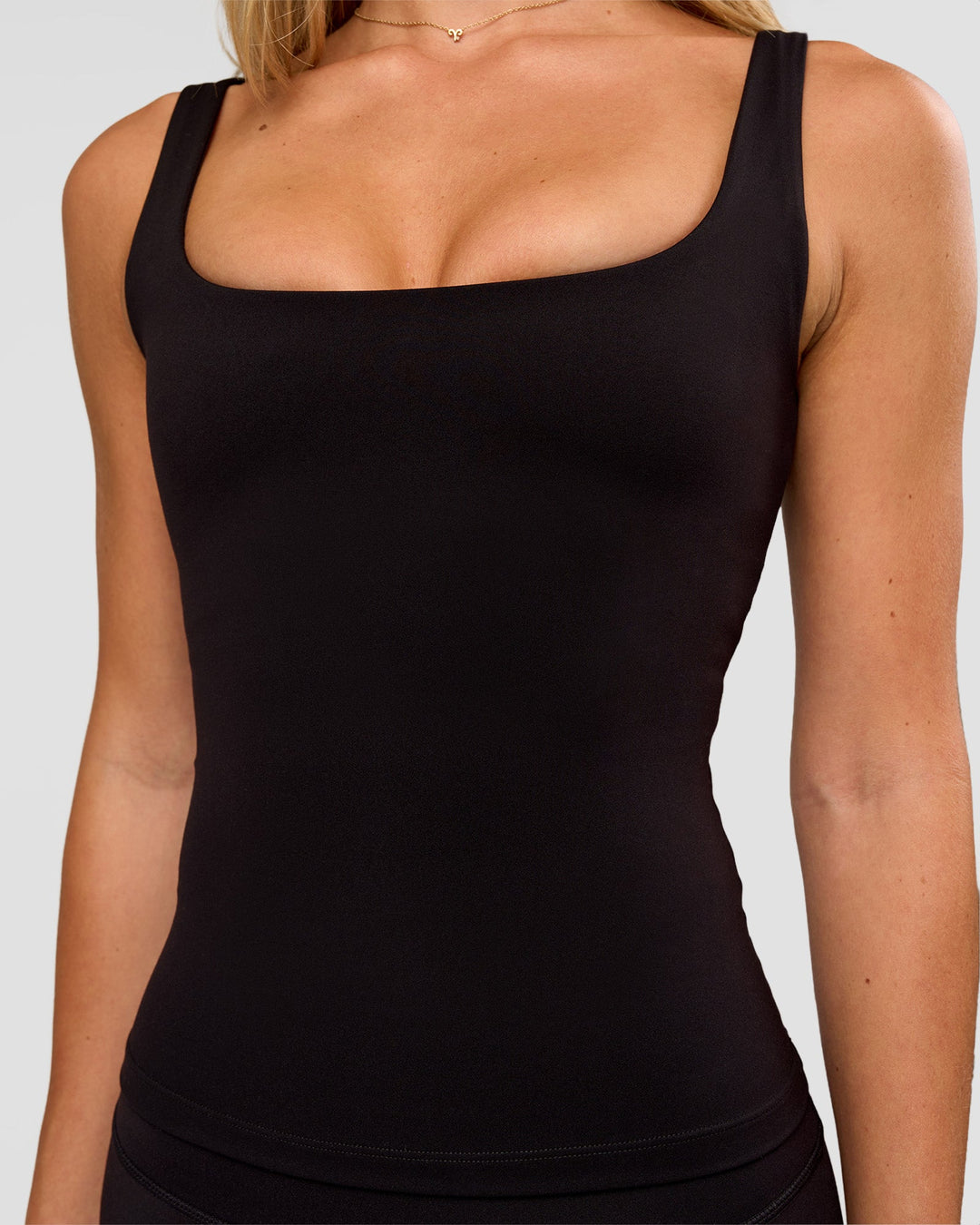 Woman wearing Twist Square Neck Shelf Bra Tank in Black | Model:Issy | Size:XS
