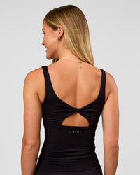 Woman wearing Twist Square Neck Shelf Bra Tank in Black | Model:Issy | Size:XS
