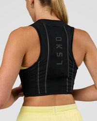 Woman wearing Pace Running Vest - Black-Reflective | Model:Evie | Size:XS/S