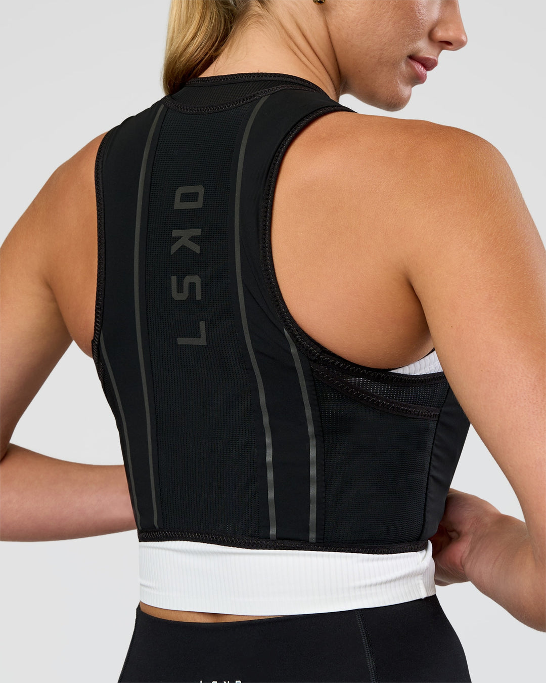 Woman wearing Pace Running Vest - Black-Reflective | Model:Evie | Size:XS/S