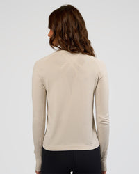 Woman wearing AeroFLX+ Long Sleeve Half Zip - Shale Beige/Shale Beige | Model:Dakota | Size:XS