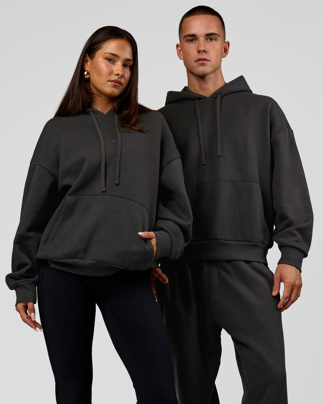 Duo wearing Base Oversized DC Hoodie - Onyx | Model:Albert | Size:M | Model:Bianca | Size:XS - view 1
