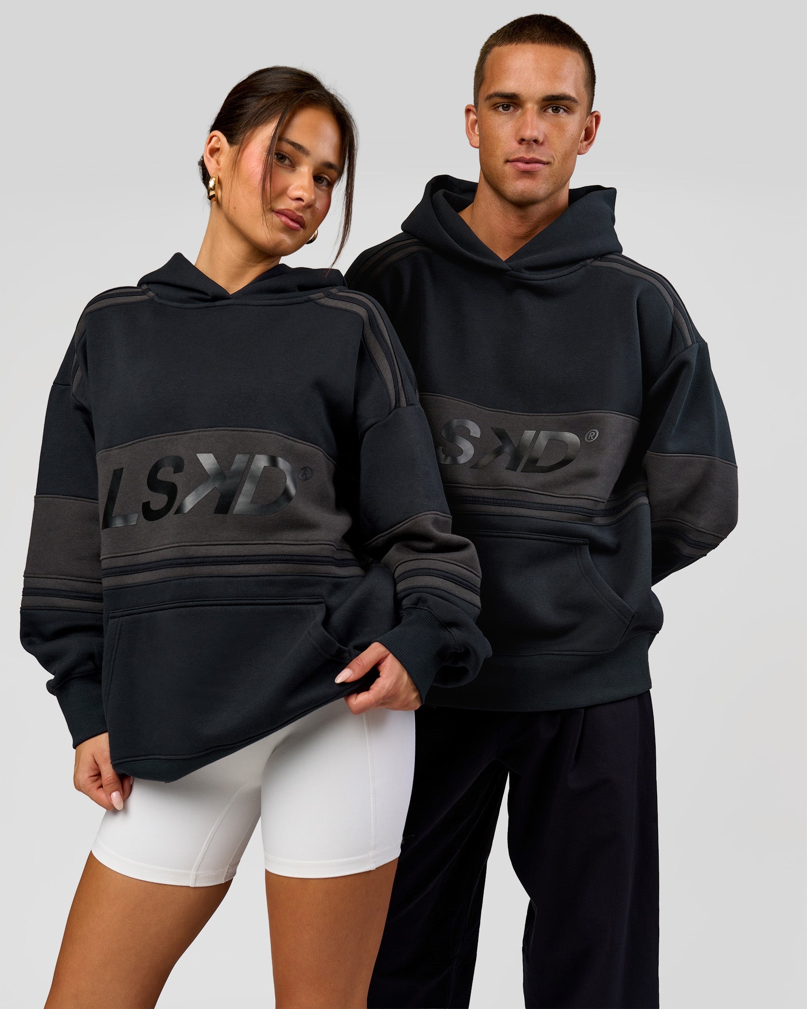 Duo wearing A-Team Oversized Hoodie - Caviar-Onyx | Model:Bianca | Size:XS | Model:Albert | Size:M