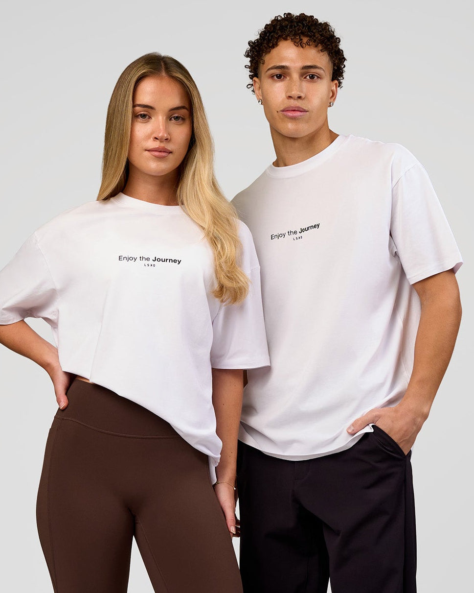 Duo wearing VS1 Enjoy The Journey FLXCotton Oversize Tee - White | Model:Issy | Size:XS | Model:Leandro | Size:M