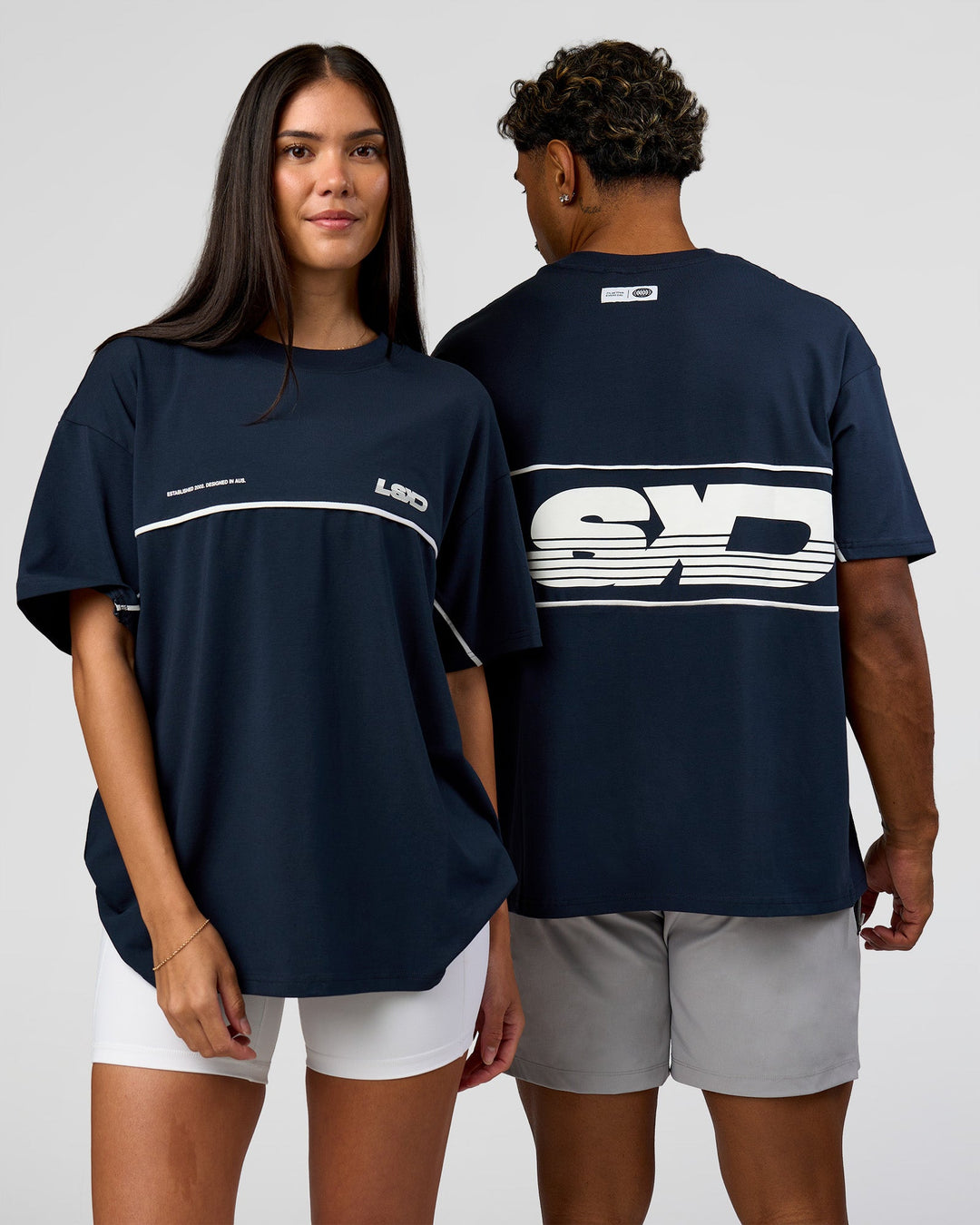 Duo wearing Inline Heavyweight FLXCotton Oversized Tee - Midnight Navy-White | Model:Rhiley | Size:XS | Model:Xav | Size:L - view 1
