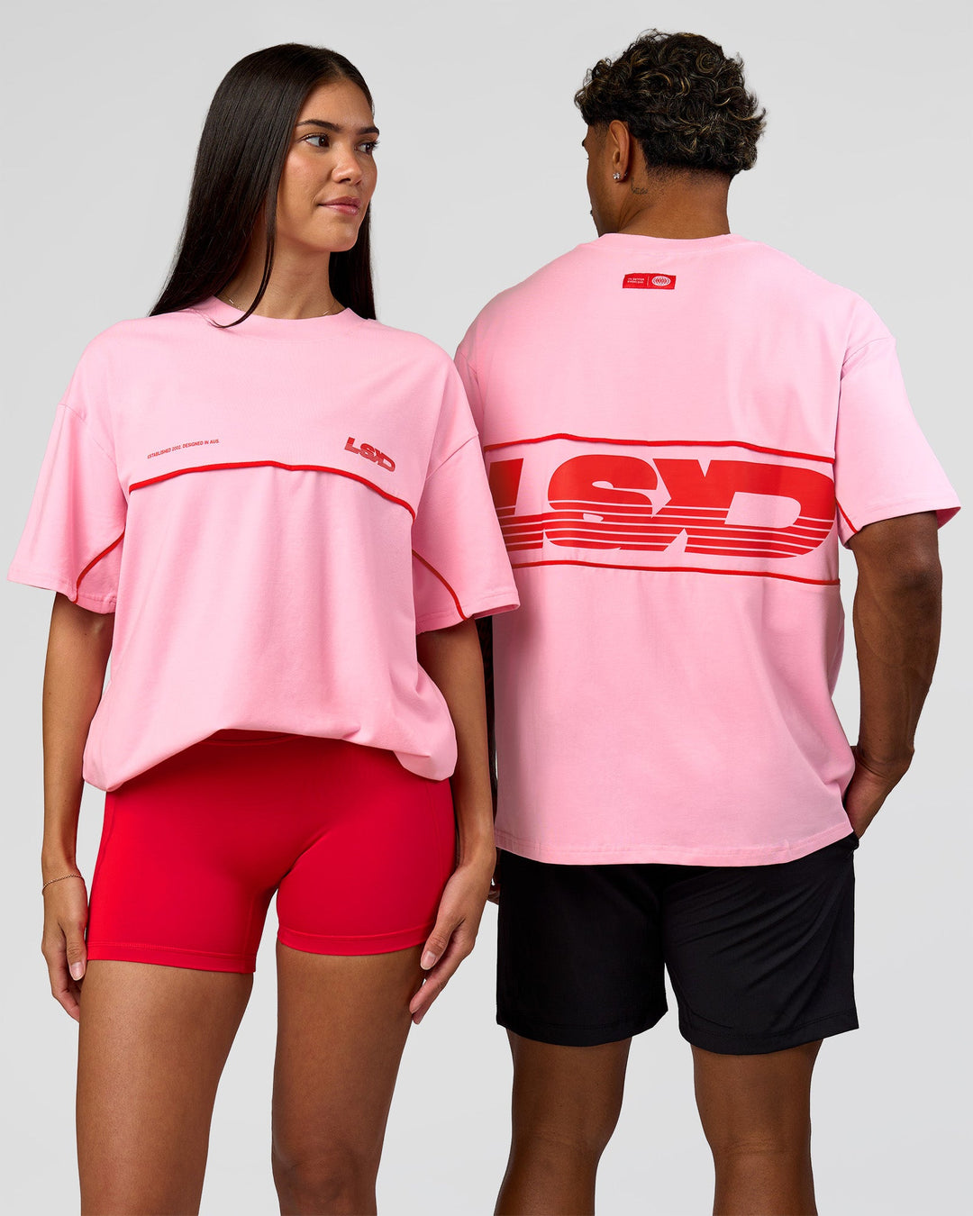Duo wearing Inline Heavyweight FLXCotton Oversized Tee - Pink Rose-Flame | Model:Rhiley | Size:XS | Model:Xav | Size:L - view 1