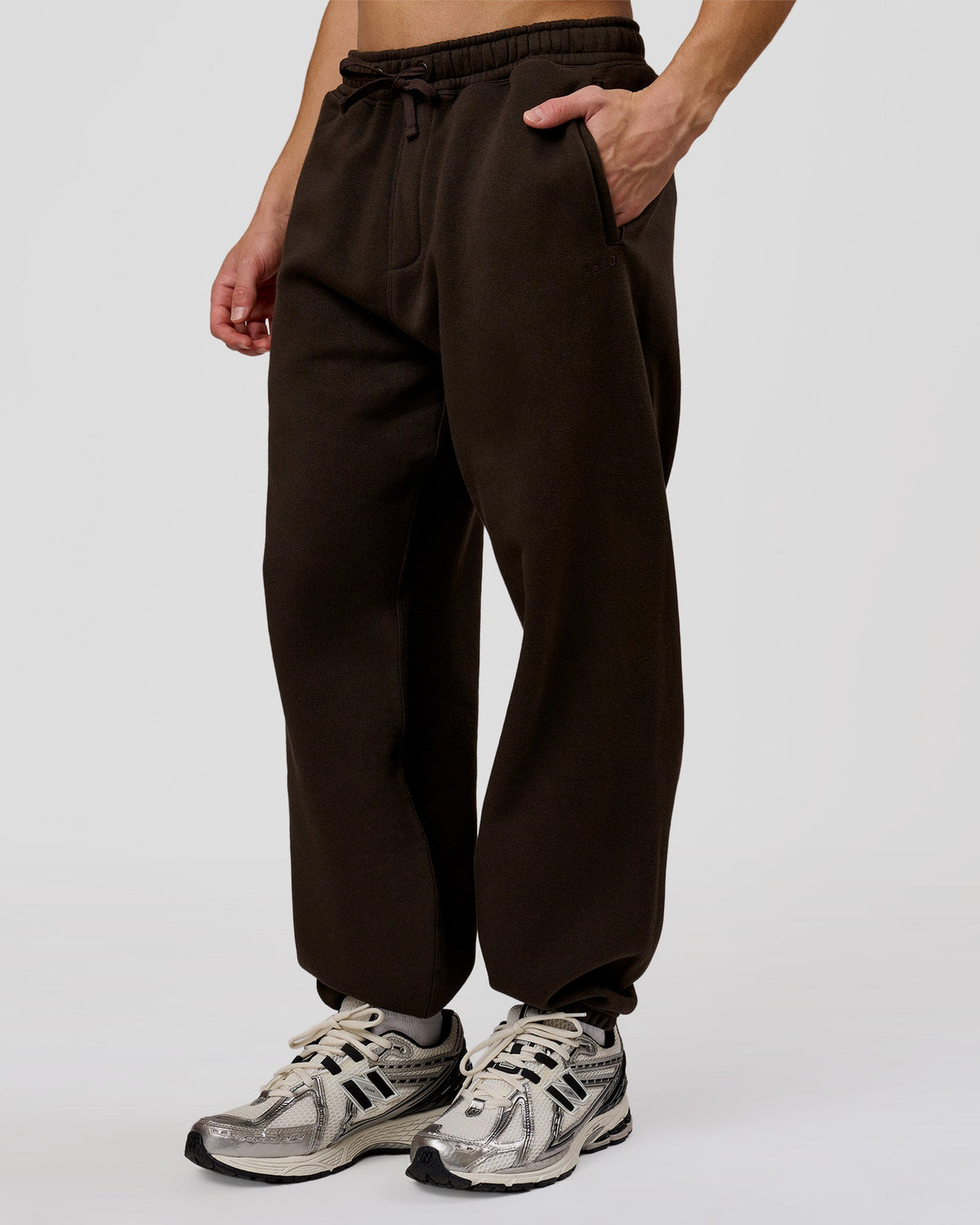 Man wearing Base Baggy Cuffed Track Pant - Ground Coffee | Model:Leandro | Size:M