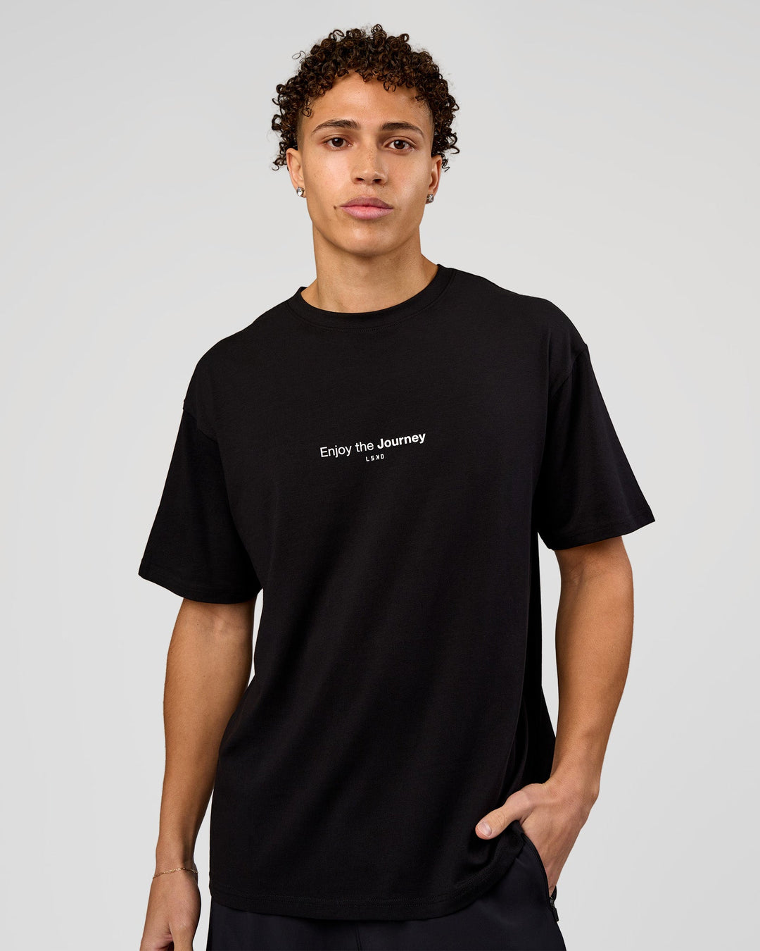 Man wearing VS1 Enjoy The Journey FLXCotton Oversize Tee - Black | Model:Leandro | Size:M - view 2