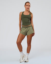 Woman wearing Accelerate 3" Mid-Rise Running Short - Pure Olive-Fog | Model:Xs | Size:ISSY | Thumbnail Index: 2