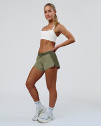 Woman wearing Accelerate 3" Mid-Rise Running Short - Pure Olive-Fog | Model:Xs | Size:ISSY | Thumbnail Index: 1