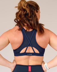 Woman wearing Unstoppable Racerback Sports Bra - Future Navy | Model:Tia | Size:M | Thumbnail Index: 2