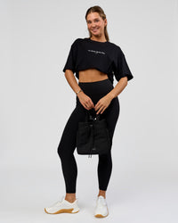 Woman wearing O.G. Fusion High-Rise Full Length Legging Pockets - Black | Model:Amity | Size:S | Thumbnail Index: 5