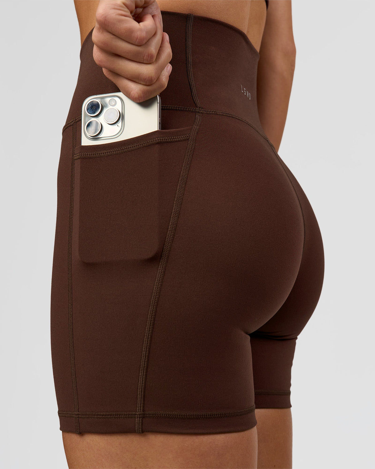 Woman wearing O.G. Fusion Ultra High-Rise 6" Short Pockets - Hot Chocolate | Model:Amity | Size:S - view 1