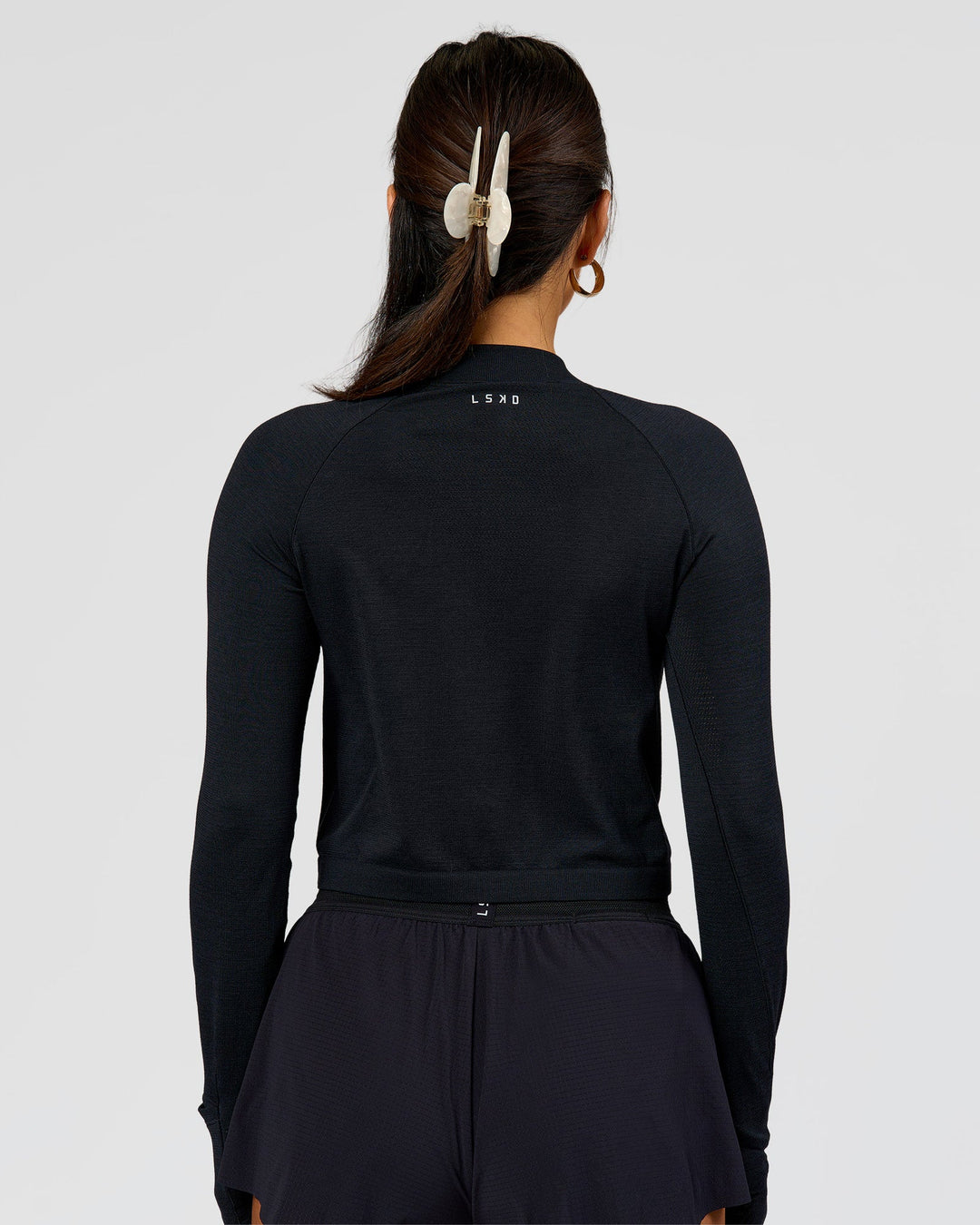 Woman wearing AeroFLX+ Long Sleeve Skimmer Half Zip - Black Marl | Model:Bianca | Size:S