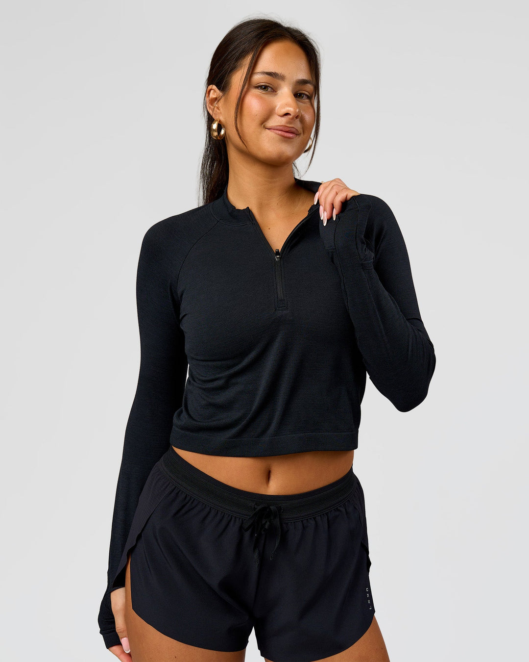 Woman wearing AeroFLX+ Long Sleeve Skimmer Half Zip - Black Marl | Model:Bianca | Size:S