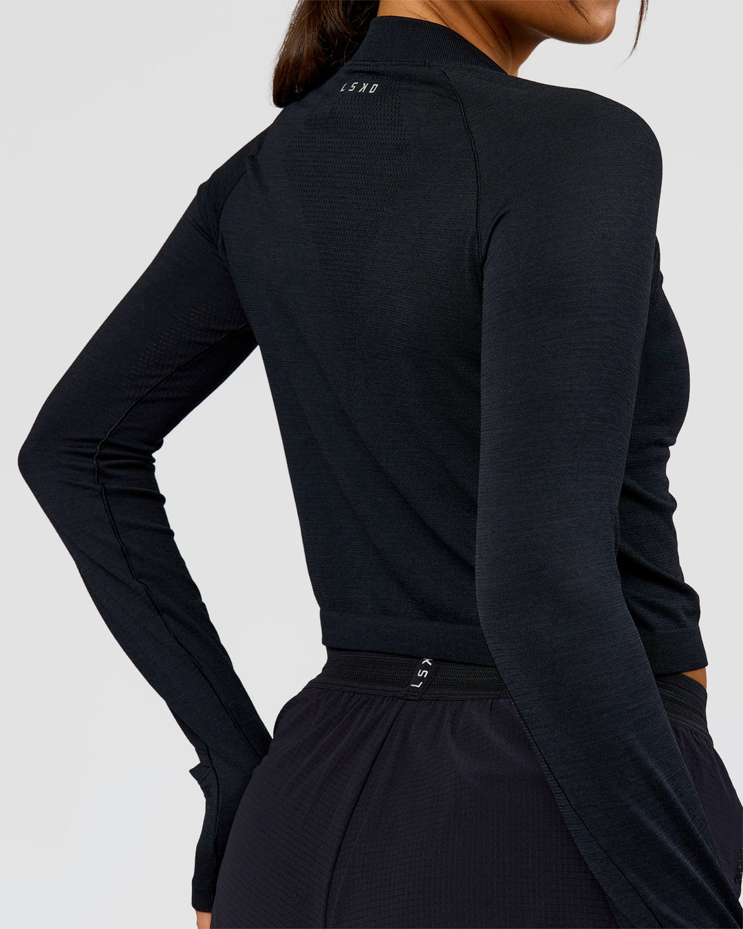 Woman wearing AeroFLX+ Long Sleeve Skimmer Half Zip - Black Marl | Model:Bianca | Size:S