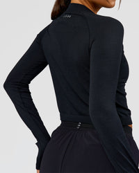 Woman wearing AeroFLX+ Long Sleeve Skimmer Half Zip - Black Marl | Model:Bianca | Size:S