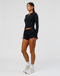 Woman wearing AeroFLX+ Long Sleeve Skimmer Half Zip - Black Marl | Model:Bianca | Size:S