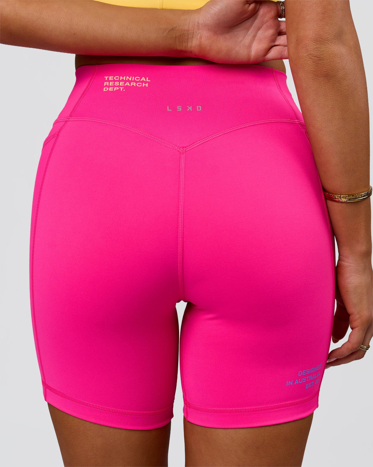 Woman wearing Fusion V-Contour High-Rise 6" Short Pockets - Ultra Pink-Tech Department | Model:Bianca | Size:S