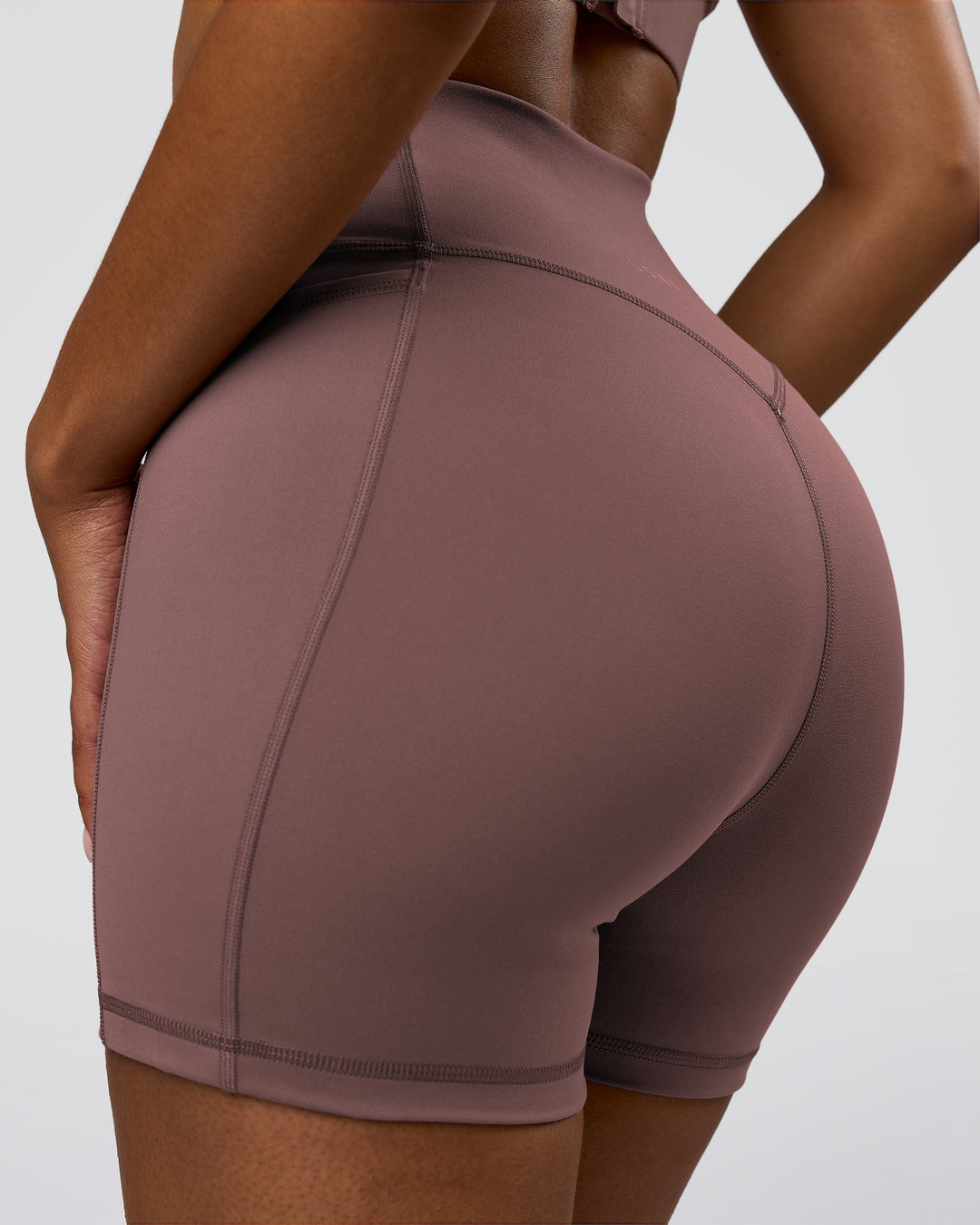 Woman wearing Fusion V-Contour Ultra High-Rise 4" Short Pockets - Cocoa Powder | Model:Jordan | Size:S - view 1