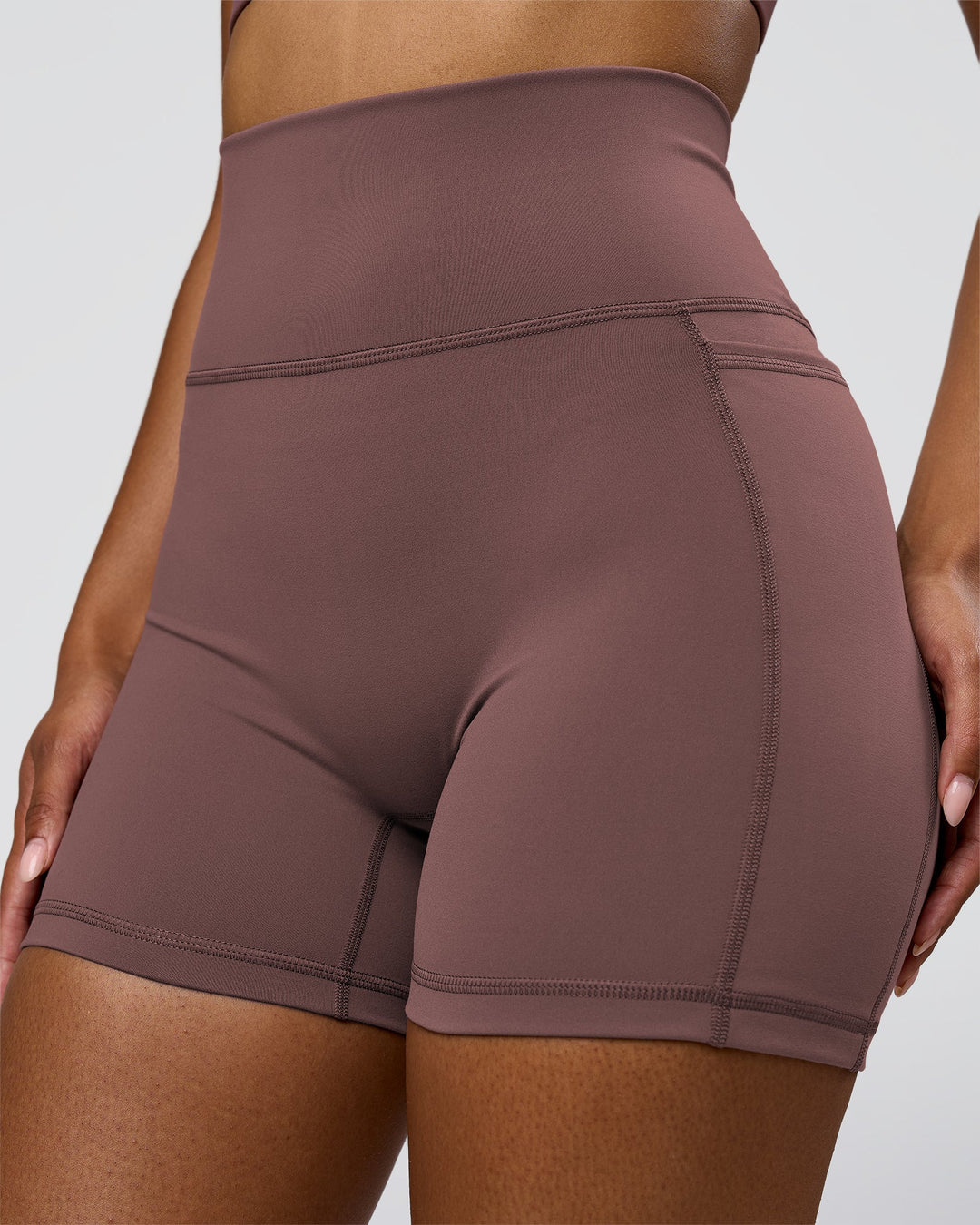 Woman wearing Fusion V-Contour Ultra High-Rise 4" Short Pockets - Cocoa Powder | Model:Jordan | Size:S - view 2