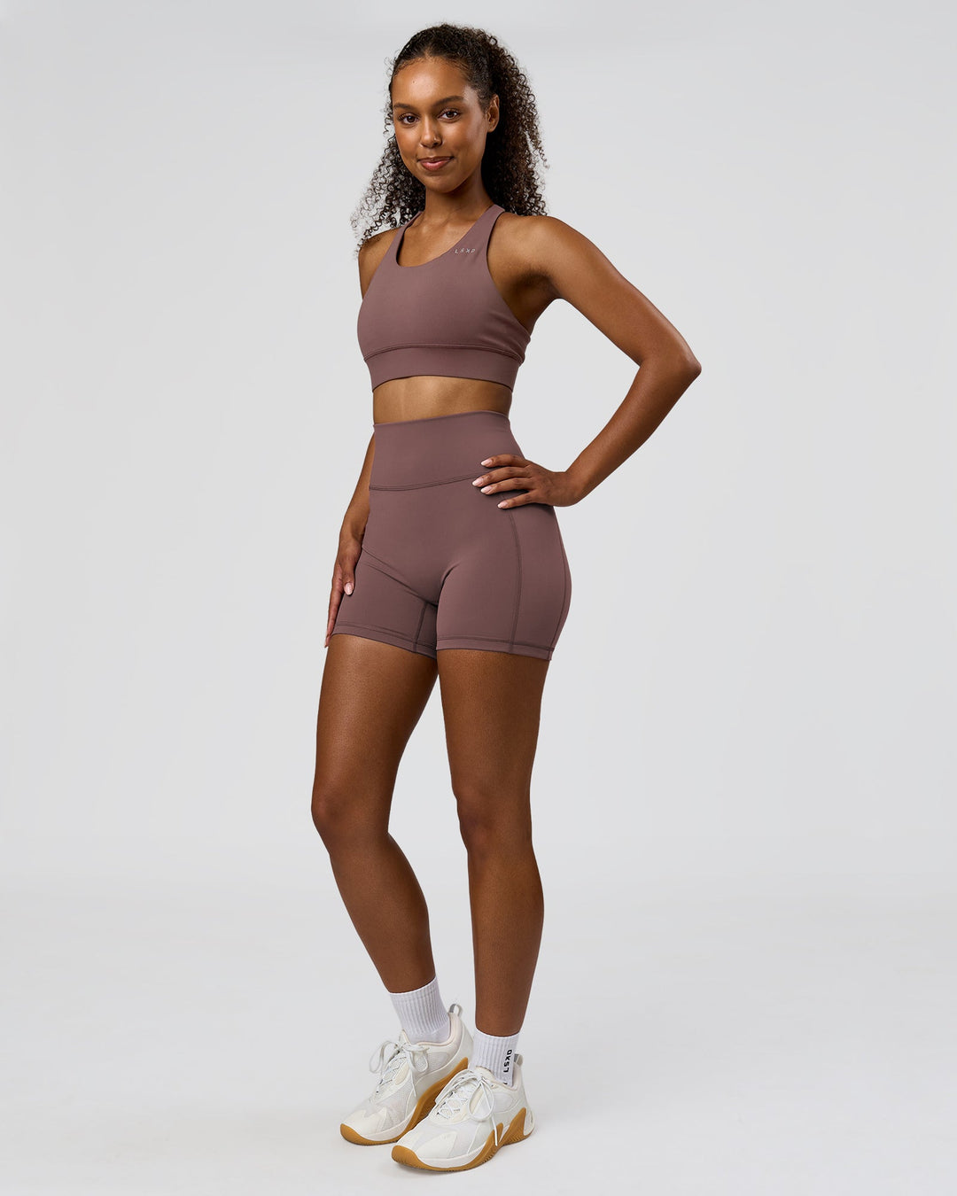 Woman wearing Fusion V-Contour Ultra High-Rise 4" Short Pockets - Cocoa Powder | Model:Jordan | Size:S - view 7