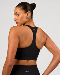 Woman wearing Flow Long Line Sports Bra - Black | Model:Rosie | Size:S | Thumbnail Index: 1