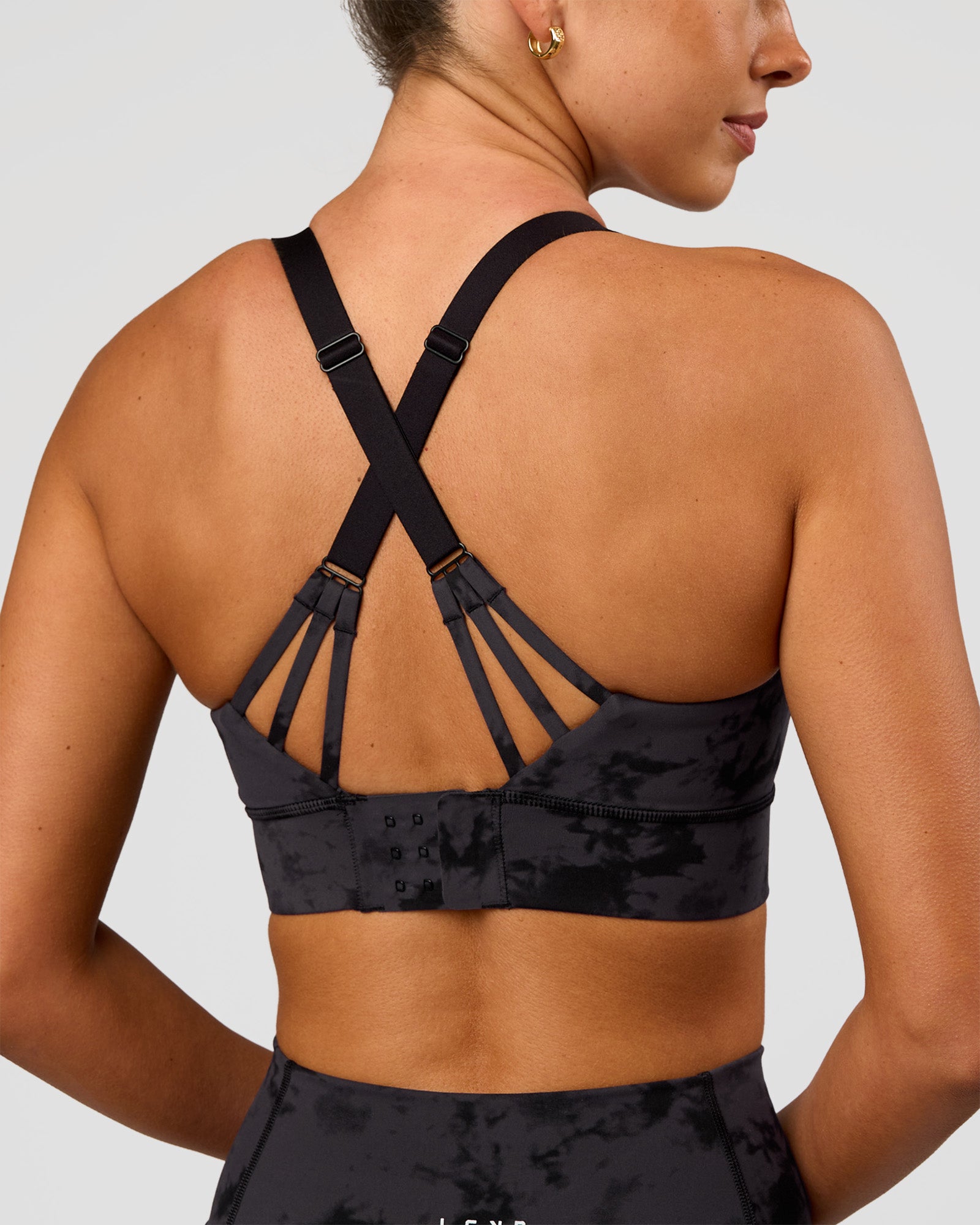 Woman wearing Accelerate Split Strap Sports Bra - Black Tie Dye | Model:Charli | Size:XS
