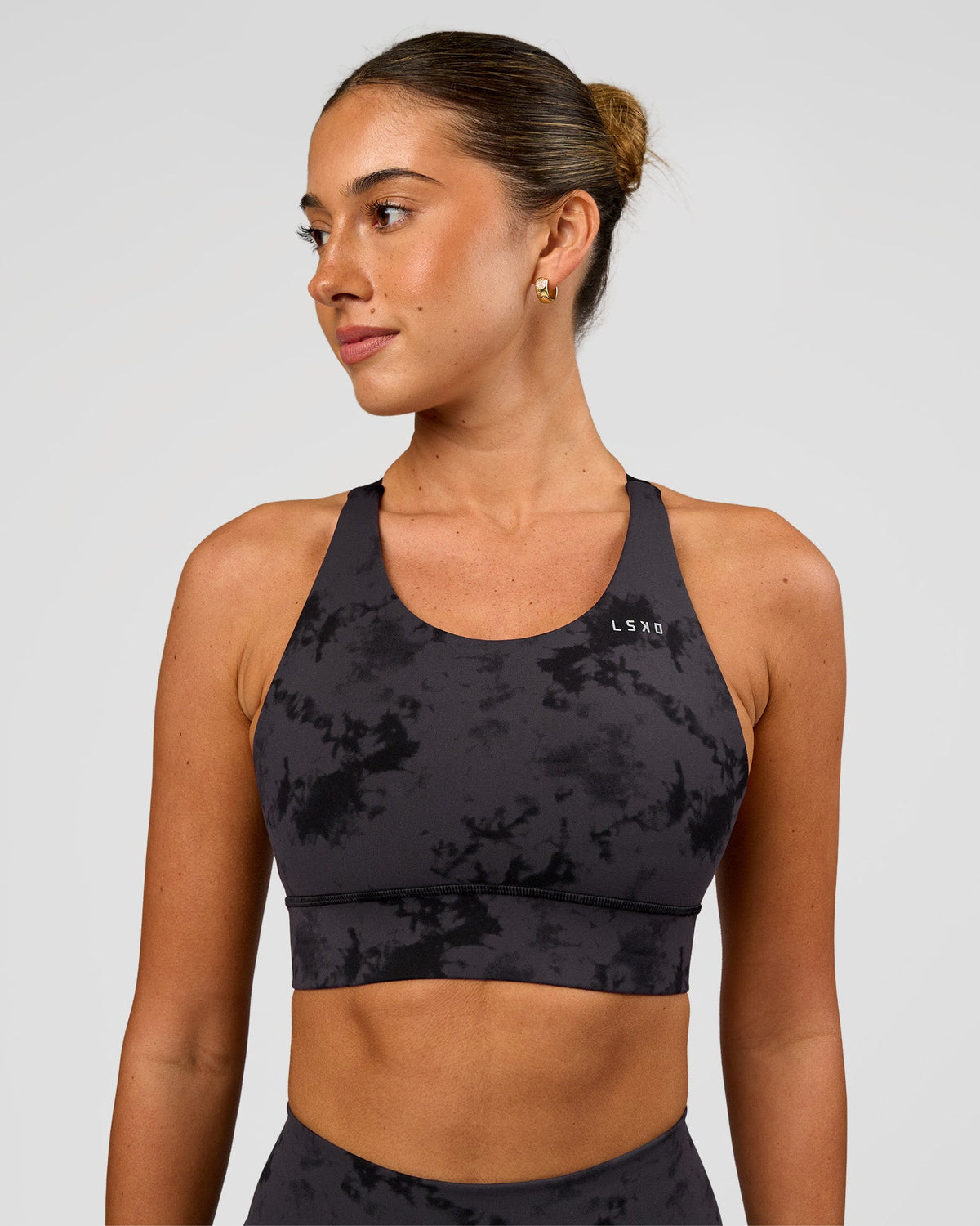 Woman wearing Accelerate Split Strap Sports Bra - Black Tie Dye | Model:Charli | Size:XS