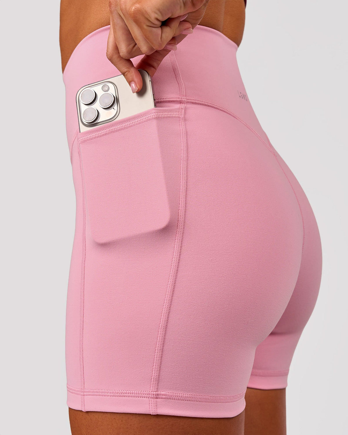 Woman wearing Fusion V-Contour Ultra High-Rise 4" Short Pockets - Pink Rose | Model:Charli | Size:XS - view 2