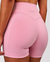 Woman wearing Fusion V-Contour Ultra High-Rise 4" Short Pockets - Pink Rose | Model:Charli | Size:XS | Thumbnail Index: 0