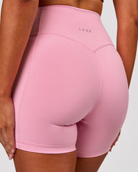 Woman wearing Fusion V-Contour Ultra High-Rise 6" Short Pockets - Pink Rose | Model:Charli | Size:XS | Thumbnail Index: 0