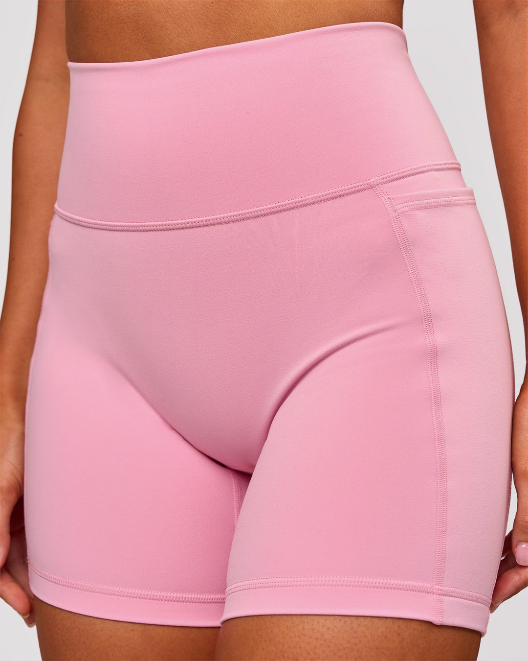 Woman wearing Fusion V-Contour Ultra High-Rise 6" Short Pockets - Pink Rose | Model:Charli | Size:XS - view 3