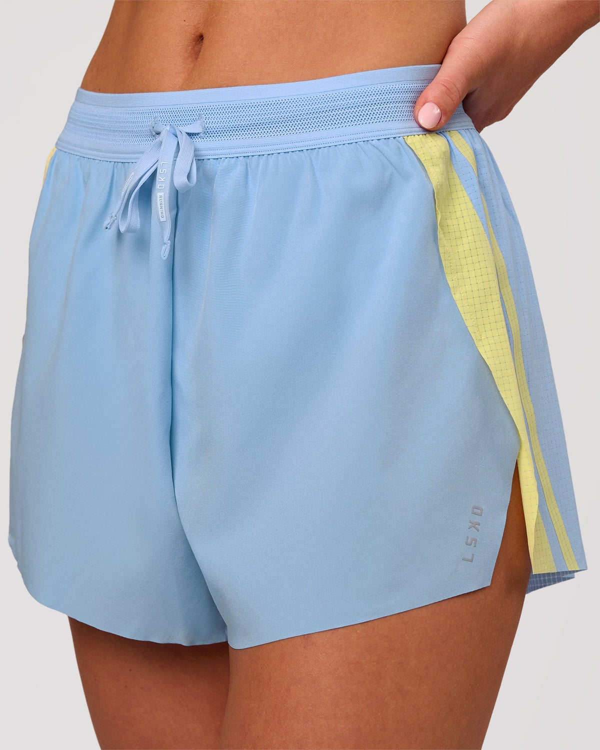 Woman wearing Accelerate 3" Force High-Rise Running Short - Open Air-Lemon | Model:Issy | Size:XS