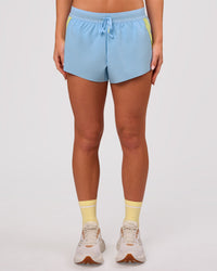 Woman wearing Accelerate 3" Force Mid-Rise Running Short - Open Air-Lemon | Model:Issy | Size:XS | Thumbnail Index: 9