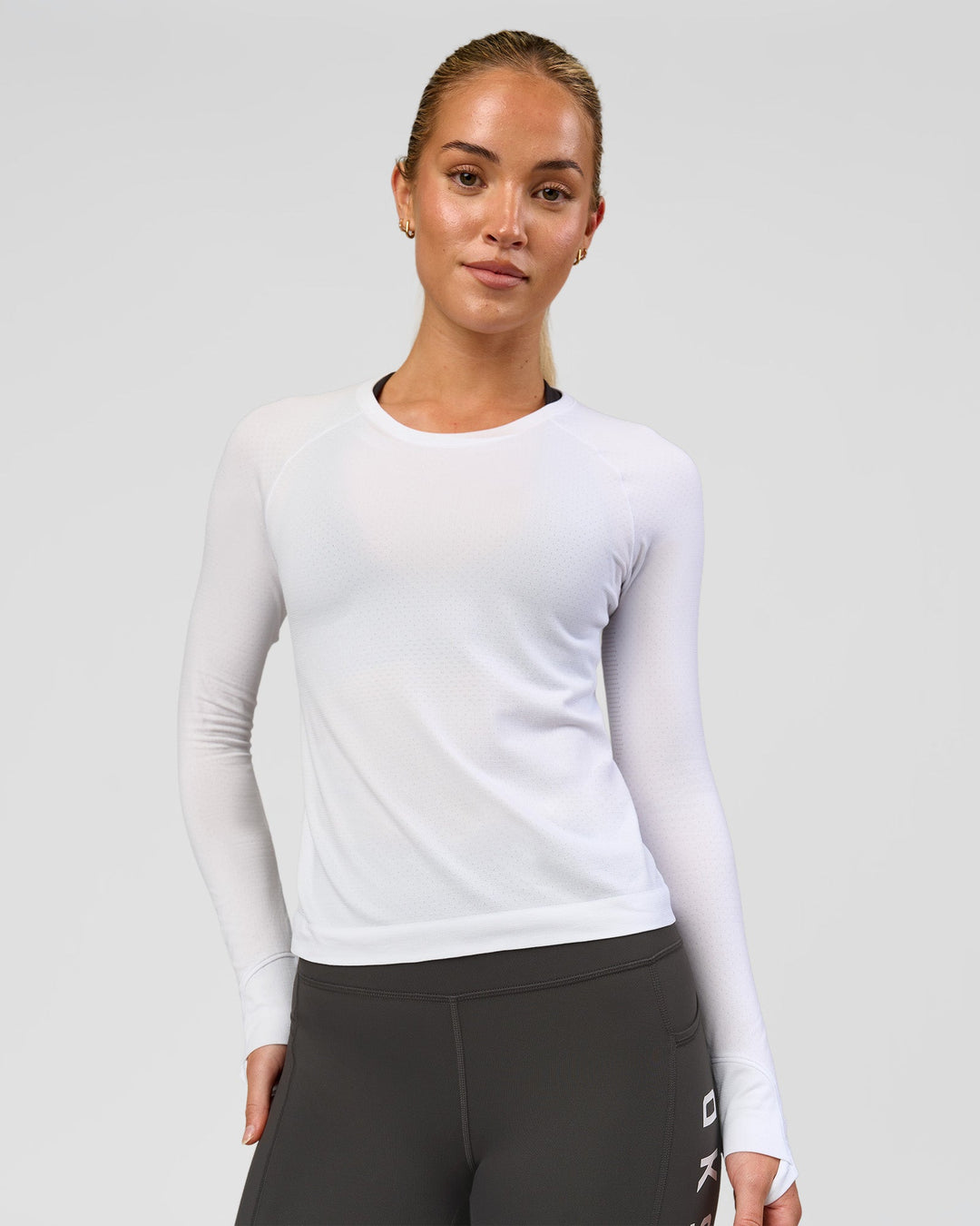 Woman wearing AeroFLX+ Seamless Long Sleeve Tee - White/White | Model:Issy | Size:XS - view 1