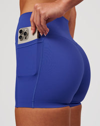 Woman wearing Elixir High-Rise 4" Short Pockets - Power Cobalt | Model:Issy | Size:XS | Thumbnail Index: 1