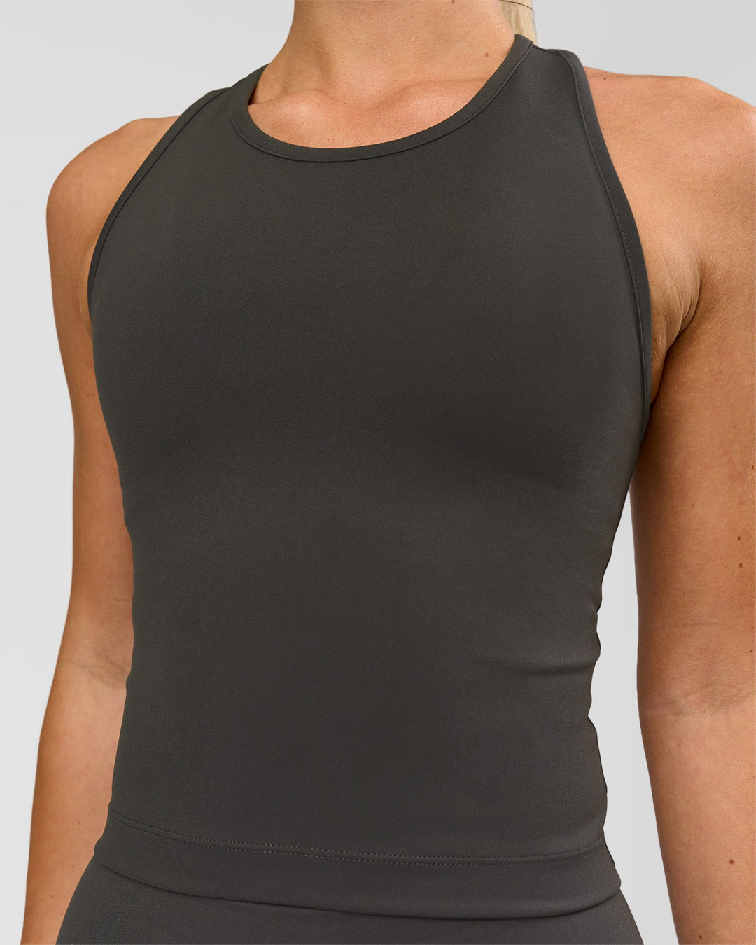 Woman wearing Flow Performance Tank 2.0 - Onyx | Model:Issy | Size:XS - view 2