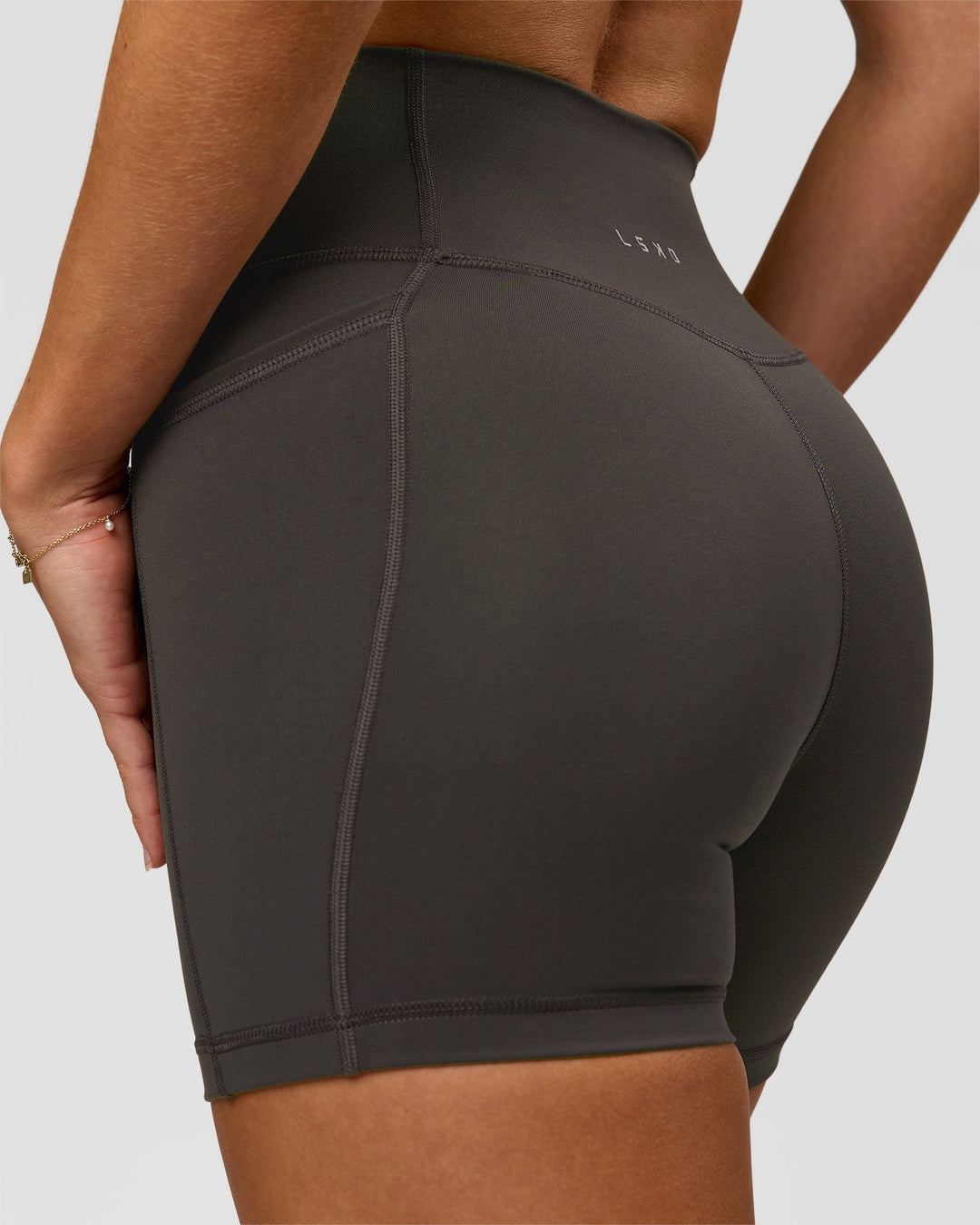 Woman wearing Fusion Ultra High-Rise 4" Short Pockets - Onyx | Model:Issy | Size:XS - view 4