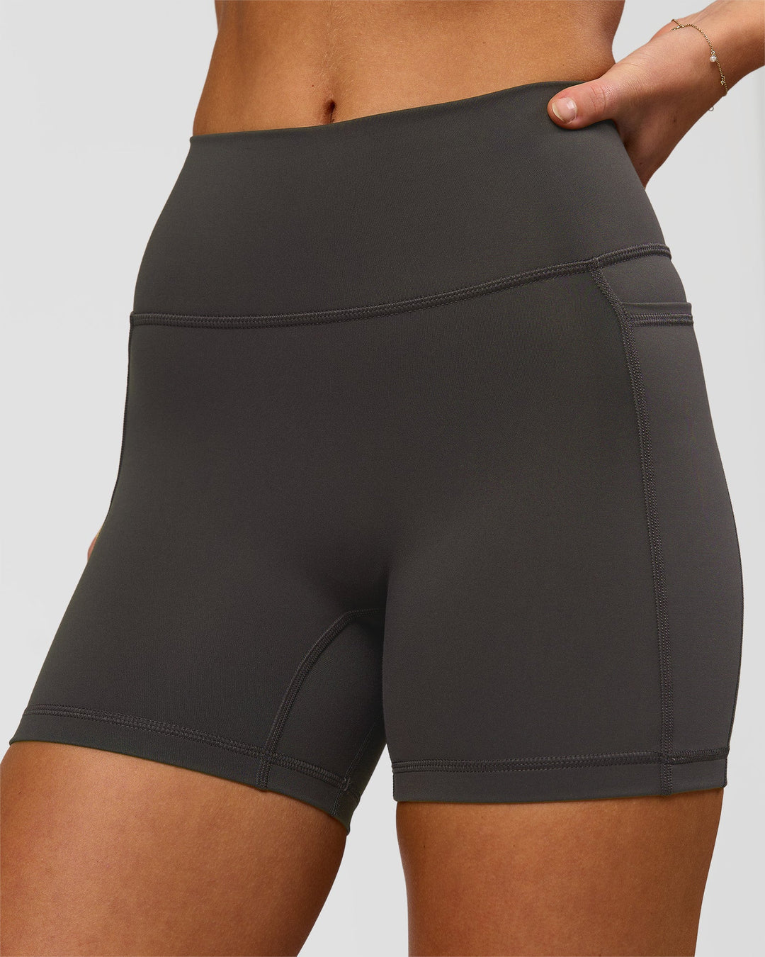Woman wearing Fusion Ultra High-Rise 4" Short Pockets - Onyx | Model:Issy | Size:XS - view 3