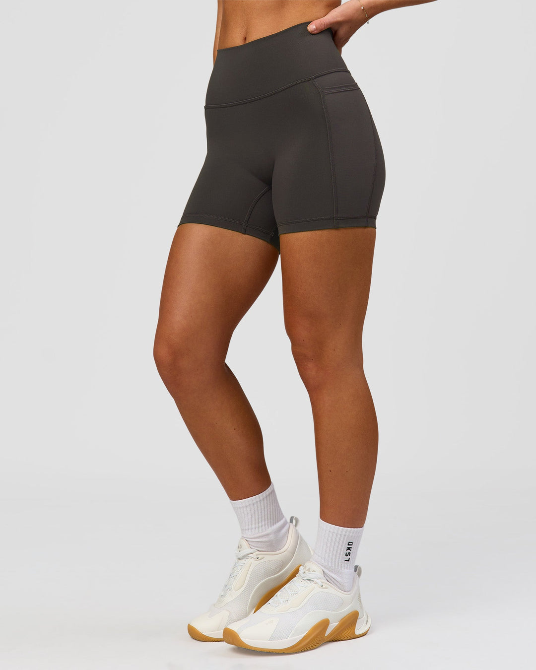 Woman wearing Fusion Ultra High-Rise 4" Short Pockets - Onyx | Model:Issy | Size:XS - view 8