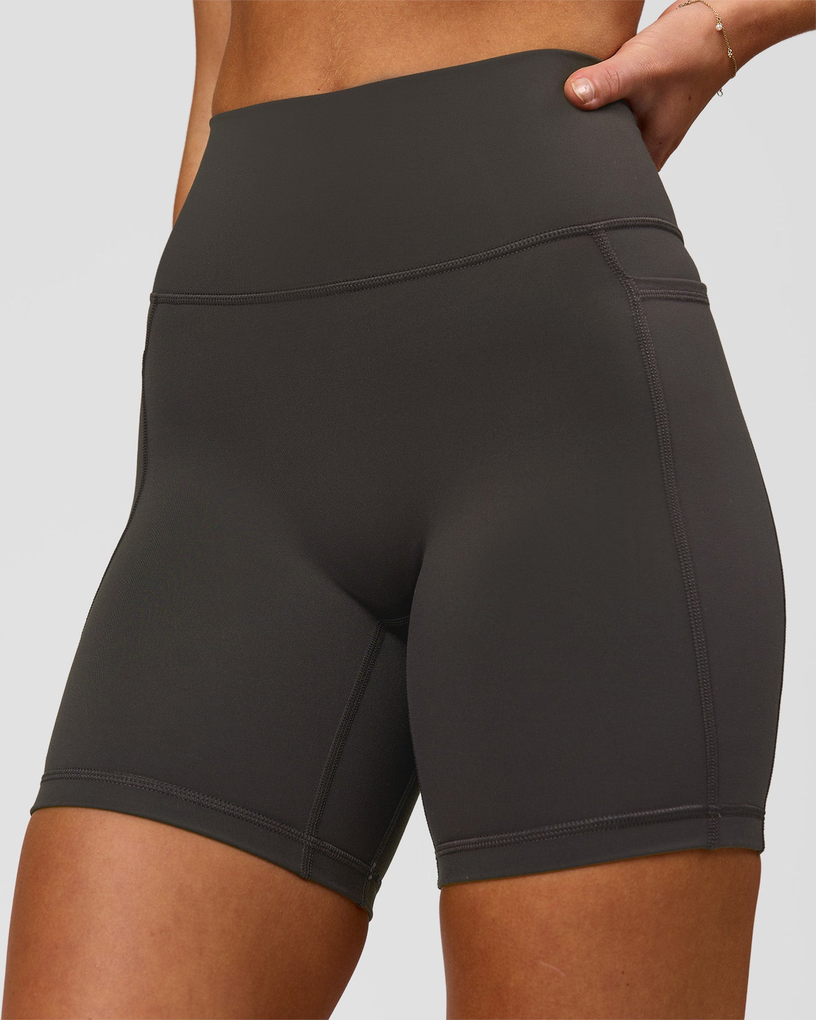 Woman wearing Fusion Ultra High-Rise 6" Short Pockets - Onyx | Model:Issy | Size:XS
