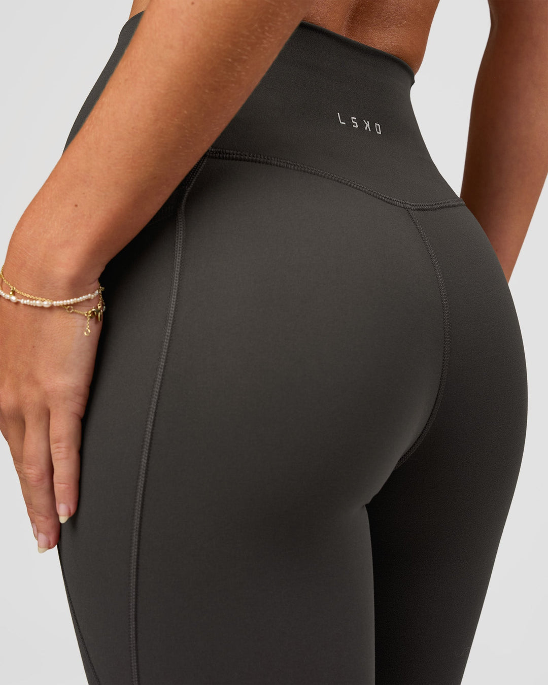 Woman wearing Fusion Ultra High-Rise 7/8 Legging Pockets - Onyx | Model:Issy | Size:XS - view 4