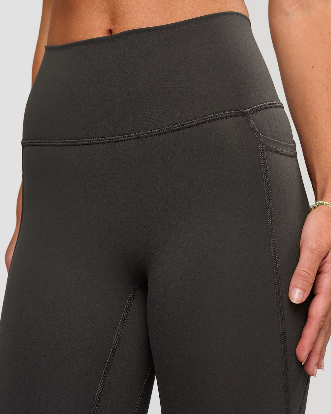 Woman wearing Fusion Ultra High-Rise 7/8 Legging Pockets - Onyx | Model:Issy | Size:XS - view 5