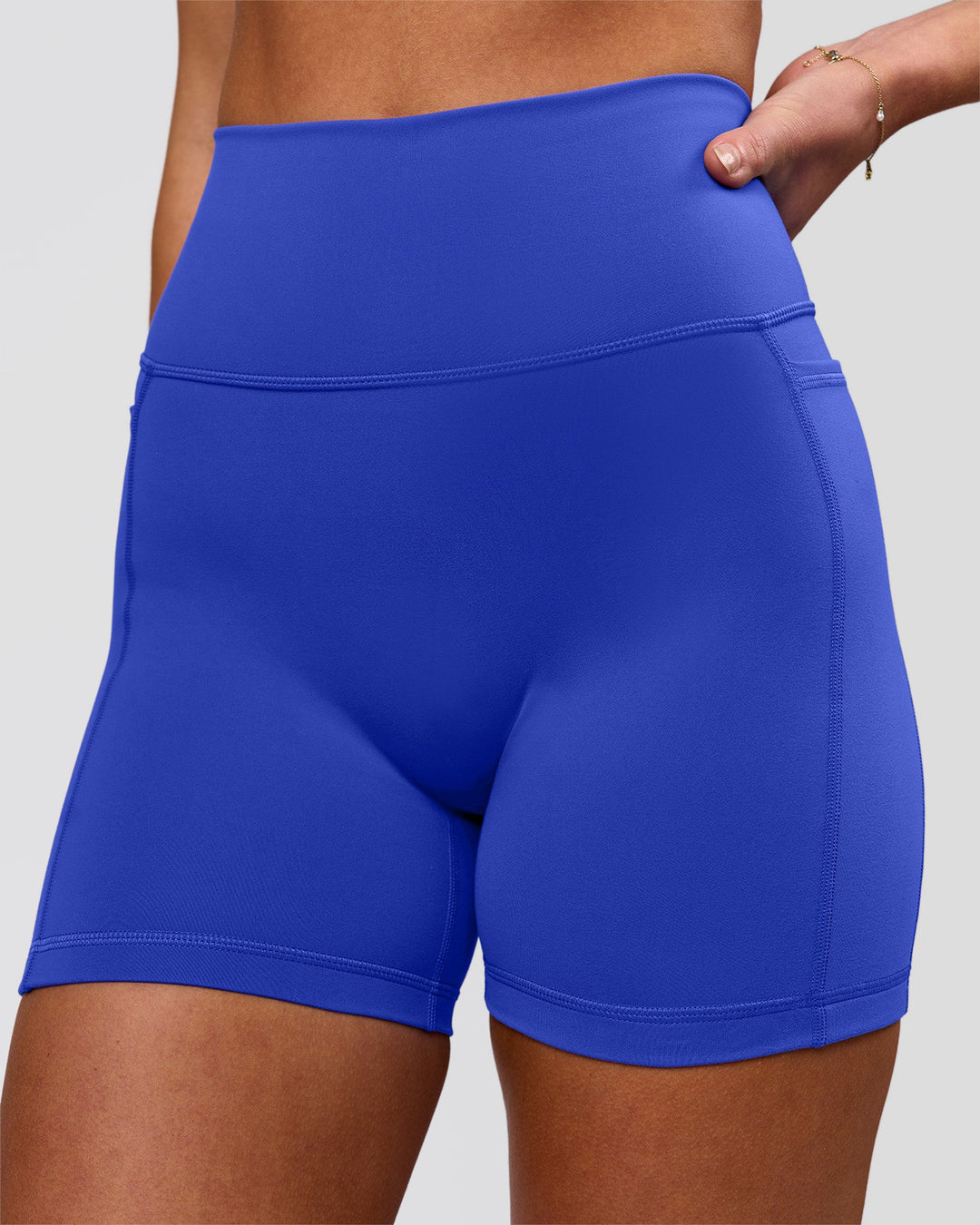 Woman wearing Fusion V-Contour Ultra High-Rise 4" Short Pockets - Power Cobalt | Model:Issy | Size:XS - view 1