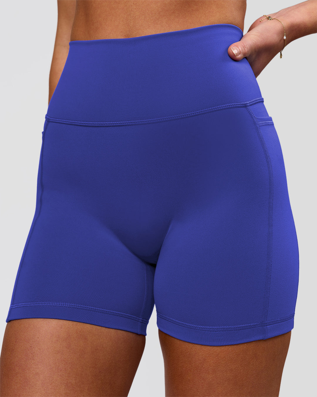 Woman wearing Fusion V-Contour Ultra High-Rise 4" Short Pockets - Power Cobalt | Model:Issy | Size:XS - view 1