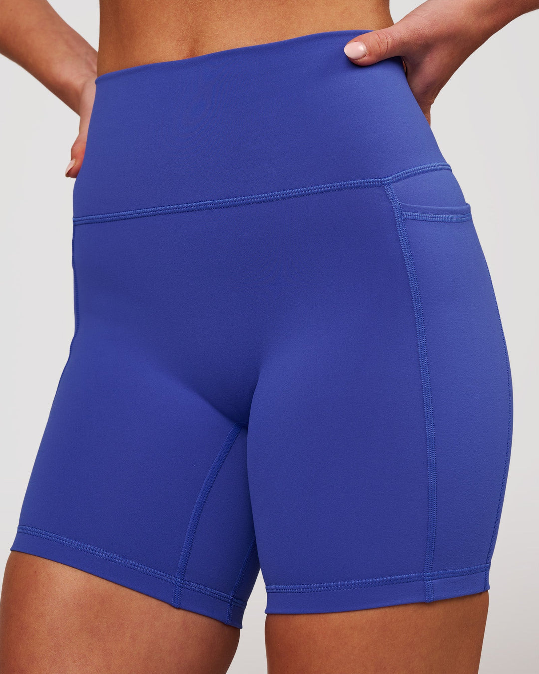 Woman wearing Fusion V-Contour Ultra High-Rise 6" Short Pockets - Power Cobalt | Model:Issy | Size:XS - view 2