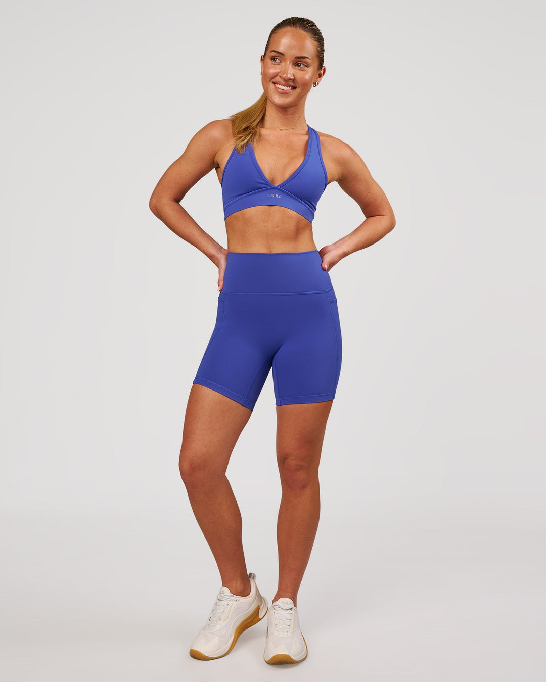 Woman wearing Fusion V-Contour Ultra High-Rise 6" Short Pockets - Power Cobalt | Model:Issy | Size:XS - view 4