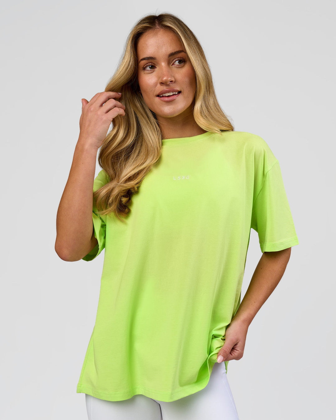 Woman wearing Go-To FLXCotton Oversized Tee - Lime Glo-White | Model:Issy | Size:XS - view 1